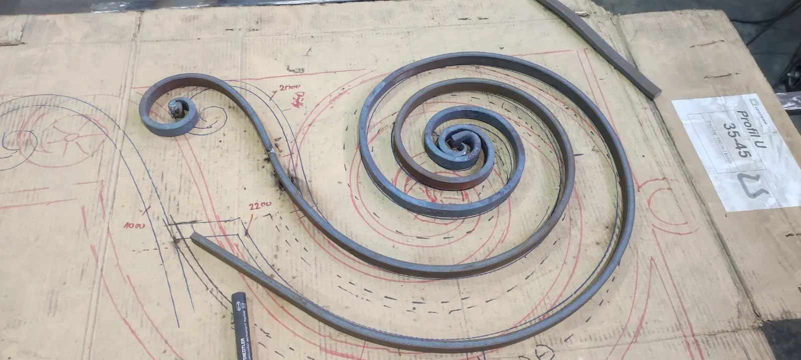 Volute en fer forgé en cours de façonnage dans l'atelier L'Art de Faire