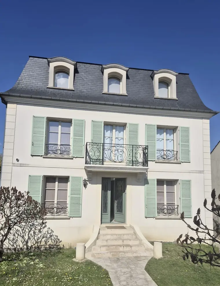 Garde-corps de balcon en fer forgé noir à volutes sur façade bourgeoise à volets verts, L'Art de Faire