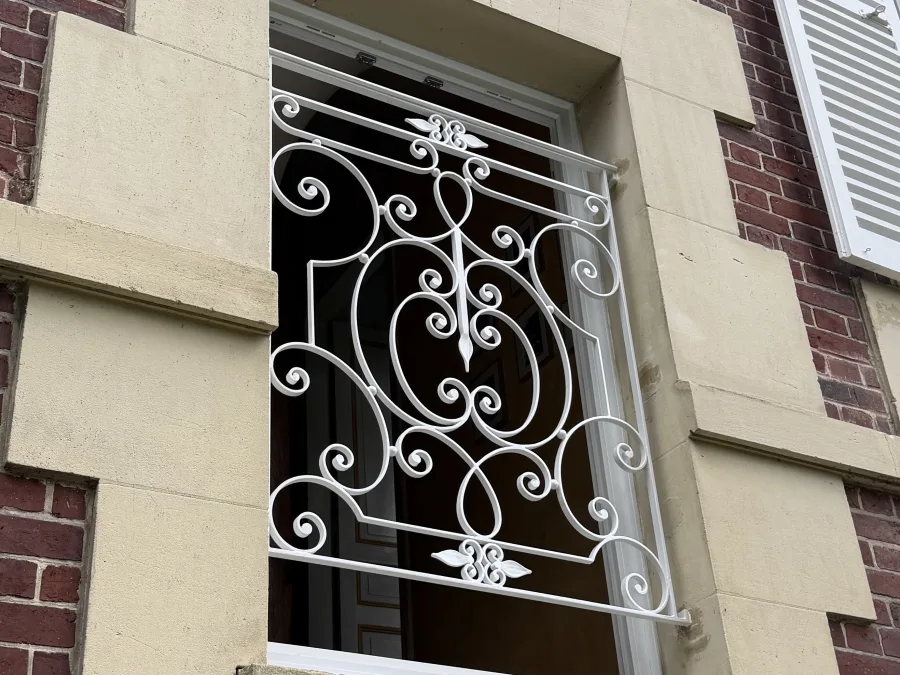 Grille de fenêtre à volutes forgées en fer forgé sur demeure de caractère, L'Art de Faire